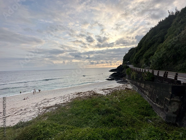 Obraz Scenic Beach with Lush Greenery and Dramatic Sky