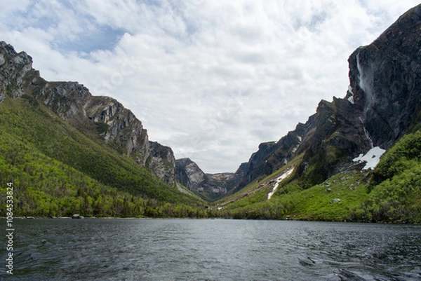 Fototapeta The eastern end of Western Brook Pond, where the fjord meets, reveals serene waters and towering cliffs, showcasing the dramatic and breathtaking beauty of Gros Morne National Park.