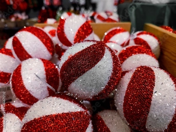 Fototapeta Red white colored Christmas baubles are on a store shelf during a Christmas show in a shop and are ready to be sold before the start of the holiday season