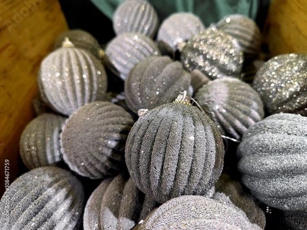 Fototapeta Silver white colored Christmas baubles are on a store shelf during a Christmas show in a shop and are ready to be sold before the start of the holiday season