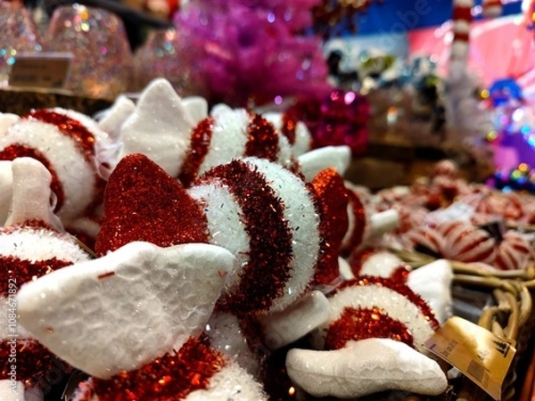 Fototapeta Red white colored candy shaped Christmas baubles are on a store shelf during a Christmas show in a shop and are ready to be sold before the start of the holiday season