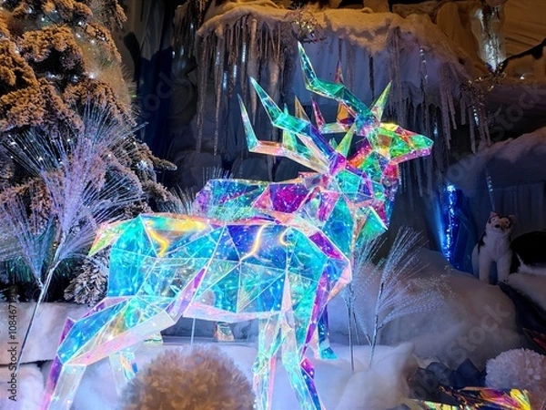 Fototapeta Shiny twinkly illuminated deer made of crystal are in a shop during a Christmas show