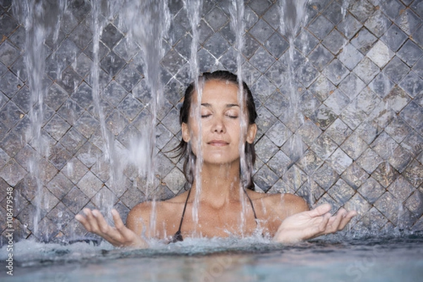 Fototapeta belle femme sous une cascade dans une piscine