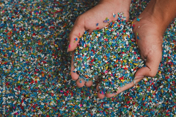 Fototapeta Hands hold clear white plastic pellets, raw materials for various manufacturing processes. These pellets are widely used in industries to produce products like packaging, bottles, and equipment parts.