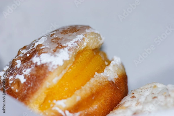 Fototapeta Bola de berlim. É um doce de farinha em froma de bola frita que depois leva no interior doce de ovos, polverizada com açucar em pó. 