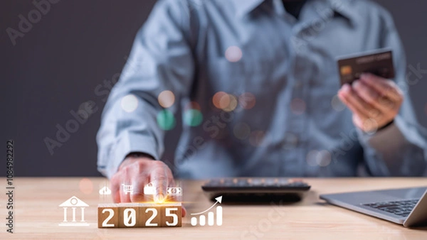 Fototapeta 2025 year. A man is holding a credit card and a laptop