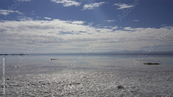 Obraz A calm seashore at sunset, showcasing golden hues and peaceful waves.