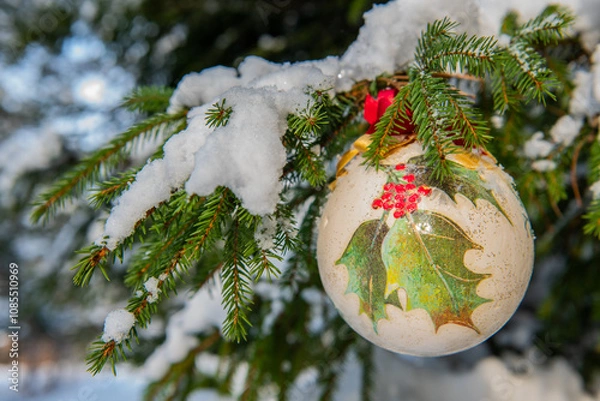 Obraz Christmas bauble hanging on a Christmas tree covered in snow