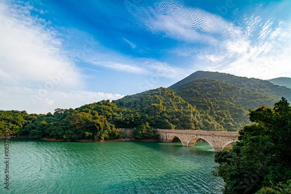 Obraz Tai Tam Reservoir in Hong Kong. It is surrounded by the Tai Tam Waterworks Heritage Trail which features heritage water facilities in Hong Kong.