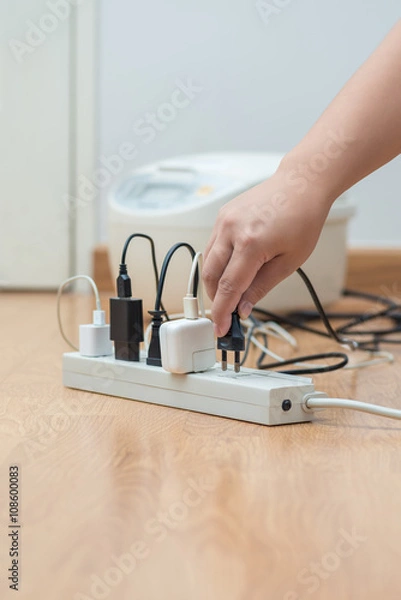 Fototapeta man unplugged plug to save on energy