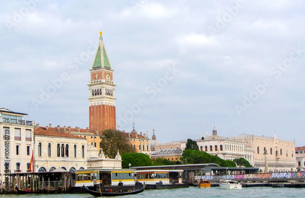 Fototapeta A view of historic Venetian buildings along the Grand Canal, showcasing classic Italian architecture. The iconic canal waters reflect the facades, with boats and gondolas adding to the charm of Venice