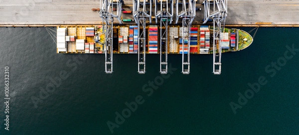 Obraz Top view of a large cargo ship loading and unloading containers at a deep sea port. Aerial view of international shipping and logistics hu