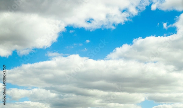 Fototapeta Photo of fluffy white clouds and bright blue sky on a sunny day.