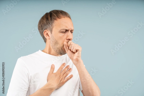 Fototapeta Unwell man struggles with persistent coughing, holding chest by sharp pain. Respiratory health problems, symptoms pneumonia, asthma attacks, allergy-induced cough with discomfort, difficulty breathing