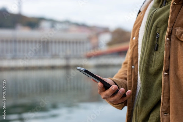 Obraz Tourist using smartphone saone river in Lyon, France