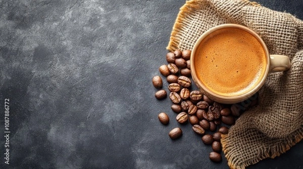 Fototapeta Coffee cup with beans on textured surface.