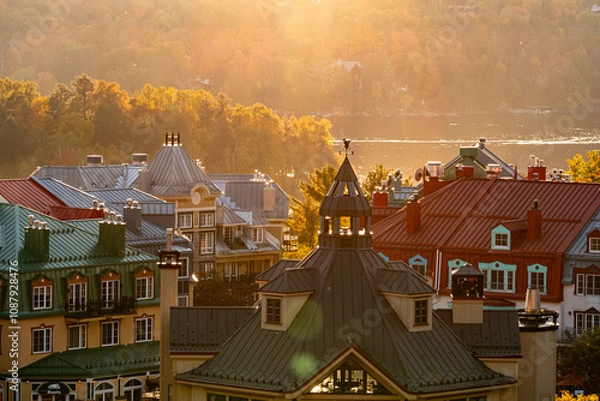 Obraz Mont-Tremblant, Quebec, Canada - October 03, 2023: House roofs surrounded by autumnal maple trees