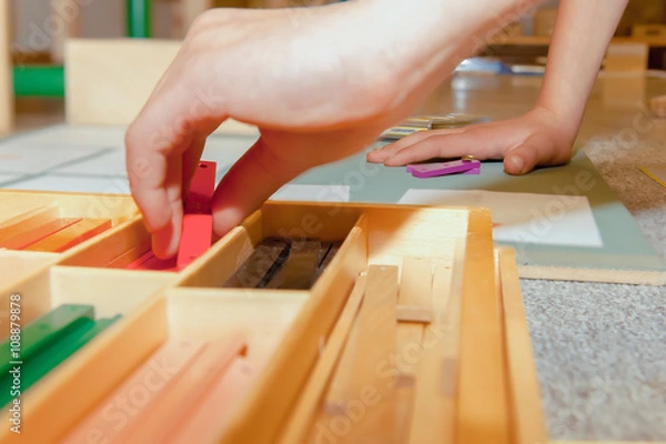 Obraz Montessori Child works with Geometric Stick Material on Cork Board