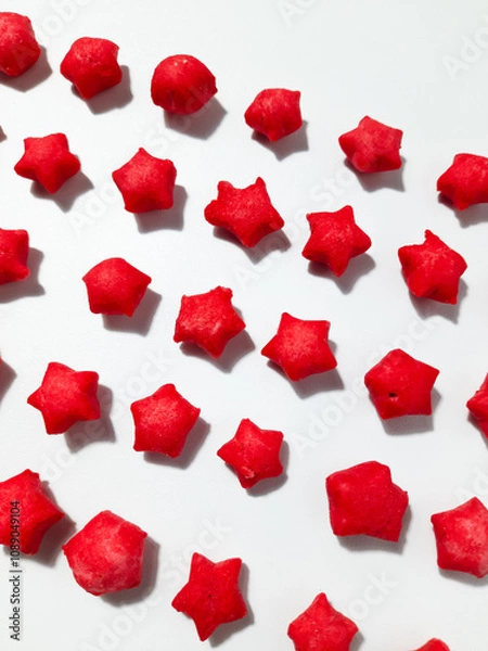 Fototapeta Pilus bintang is a unique Indonesian snack. It has a colorful star shape with a savory and crunchy taste. Served on wooden bowl. Isolated white background