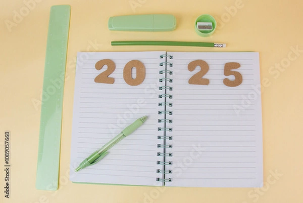 Fototapeta View of office desk with notepad with goals for 2025 and business plan for new year showing list of strategies and space for future decisions