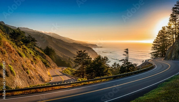 Fototapeta A road winding along the coast in the late afternoon sun with a view of the ocean