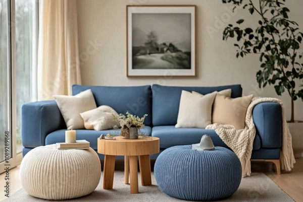 Fototapeta Two knitted poufs near dark blue corner sofa. Scandinavian home interior