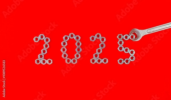 Fototapeta Number 2025 by metal nuts and wrench on a red background. Year 2025