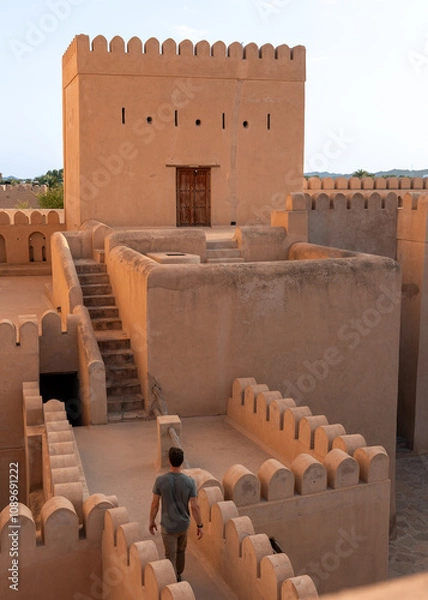 Fototapeta A man explores the historic Nizwa Fort in Oman, a remarkable symbol of the country’s rich heritage and architectural ingenuity. 