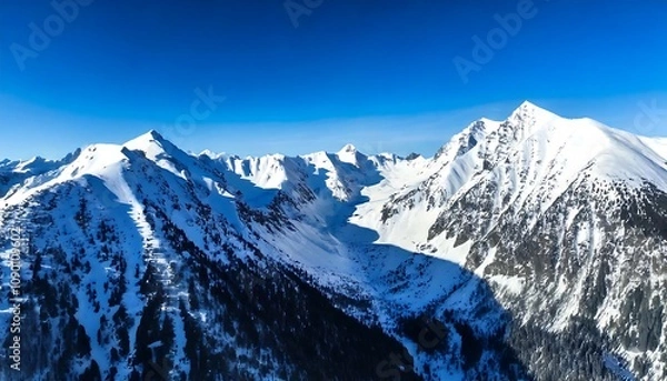 Fototapeta Aerial view of a snowy mountain range, with sharp peaks and deep blue shadows. generative ai