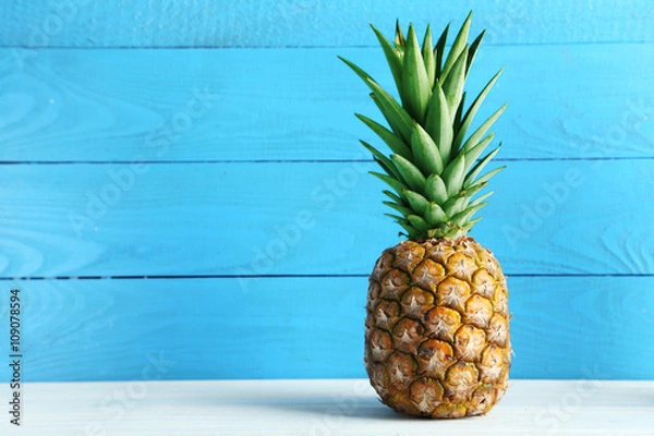 Obraz Dojrzały ananas na białym drewnianym stole