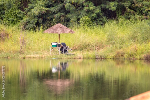 Fototapeta 여유롭고 한가한 태국의 민물 낚시터 저수지 풍경,  낚시꾼과 자연친화적인 자연산 파라솔
