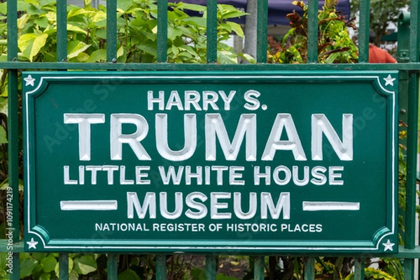 Obraz Sign for the Harry S. Truman Little White House Museum, part of the National Register of Historic Places, surrounded by greenery.