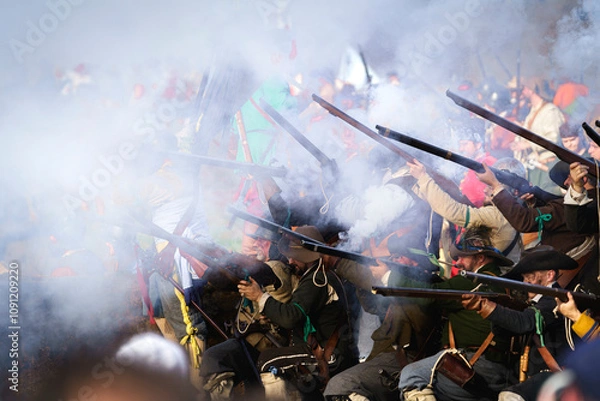Fototapeta Smoking guns and muskets with a lot of black powder smoke, fired by a historic detachment of musketeers in historical clothing from the Dutch Revolution period during the golden age of the Netherlands