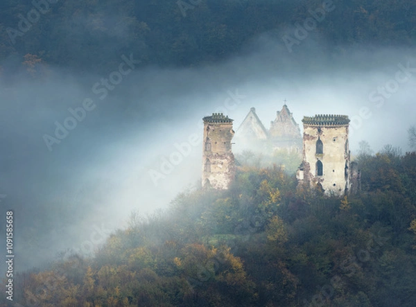 Obraz landscape with morning fog and ruins of castle and church on the hill in morning twilight