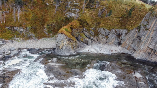 Fototapeta Cape Stolbchaty on the island of Kunashir, Kuril Islands, a unique geological volcanic formation included in the UNESCO list. Aerial drone point of