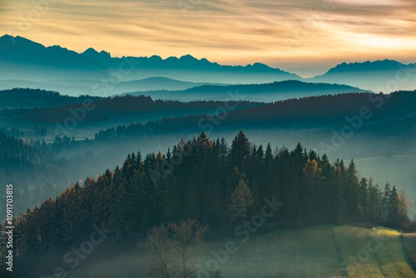 Fototapeta misty mountain ranges in the sunset light