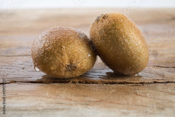 Obraz Two kiwi on wooden background