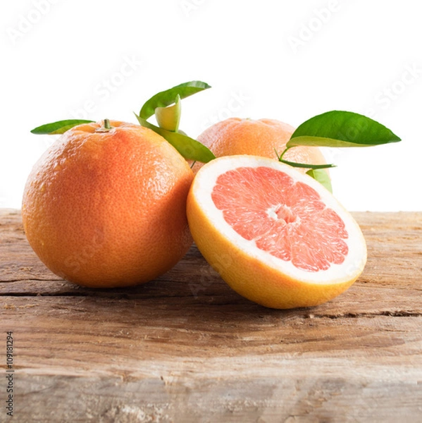 Fototapeta Grapefruit with leaves isolated on wooden background