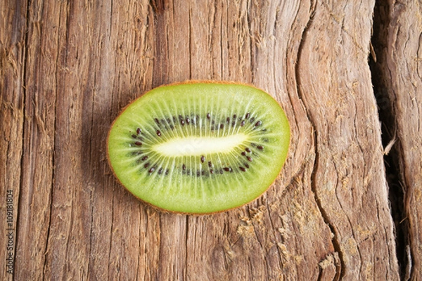 Fototapeta Kiwi slice isolated on wooden background