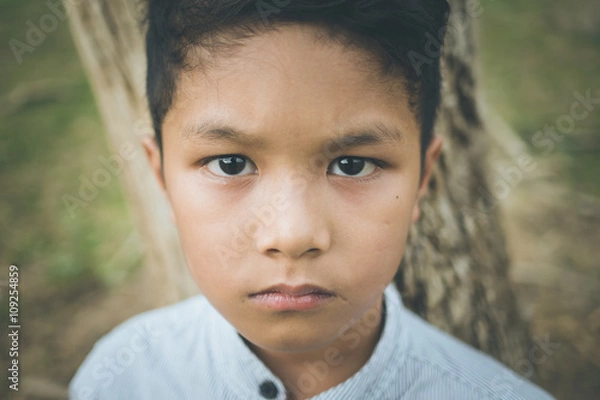 Fototapeta scared and alone, young  Asian child who is at high risk of being bullied, trafficked and abused, selective focus
