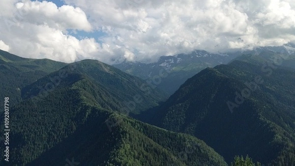 Fototapeta 
This breathtaking photo captures the lush, green expanses of the Caucasus Mountains. The rolling hills are blanketed in vibrant greenery, highlighting the rugged, untouched beauty of the region