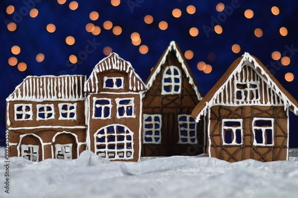 Fototapeta little home made gingerbread town with bokeh sky out of blue velvet and christmaslights as advent decoration for the family