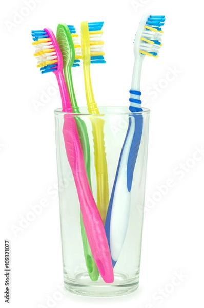 Obraz Четыре зубные щетки в стеклянном стакане на изолированном белом фоне