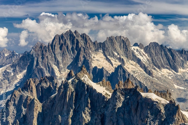 Fototapeta Snow mountains view in the Alps from Aiguille du Midi summit. Rocky mountain peaks scene covered with snow and ice of huge alpine glacier on the massive du Mont Blanc range in Chamonix