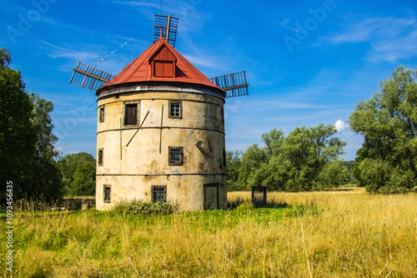 Fototapeta an old windmill in the middle of a beautiful landscape