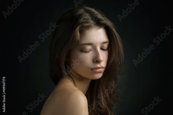 Fototapeta Dramatic portrait of a girl theme: portrait of a beautiful girl on a background in the studio
