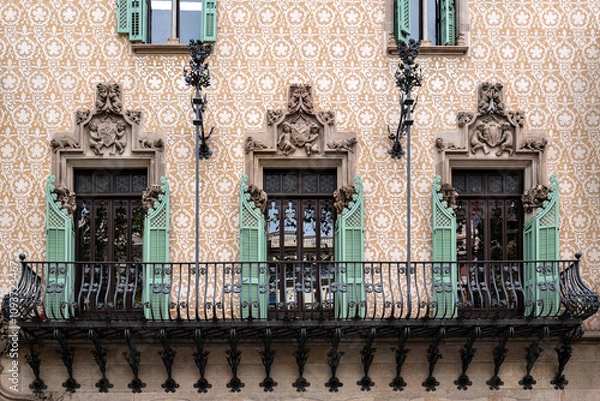 Fototapeta Balcony with cast iron rail, three rectangular windows with open green shutters and moldings. From the Peace Window Series.