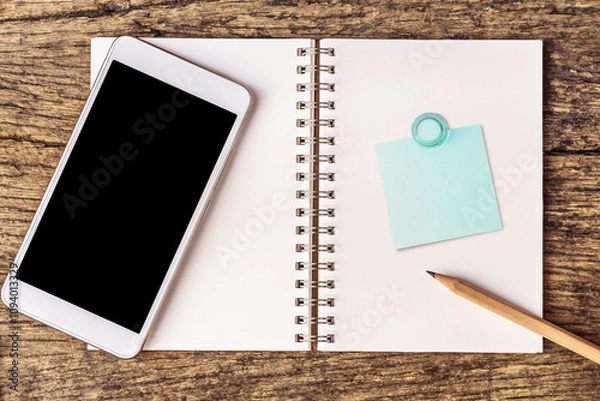 Fototapeta notebook with smartphone over  wooden table background.