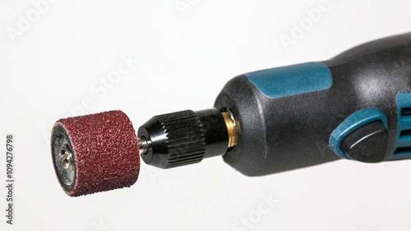 Fototapeta Electric mini grinder (fragment) with abrasive drum attachment for grinding