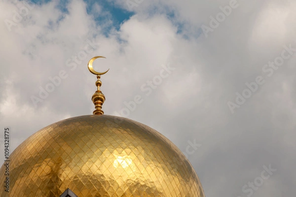 Fototapeta Gilded dome of a mosque with a crescent moon against the sky